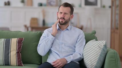 Fototapeta premium Allergic Young Man having Toothache, Cavity on Sofa 