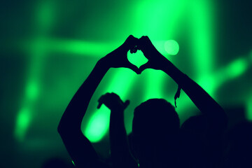 Crowd at a music concert, audience raising hands up