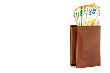 Mens brown leather wallet with a stack of Euro notes sticking out of the inside, standing isolated on a white background on the right, visible 50 Euro.