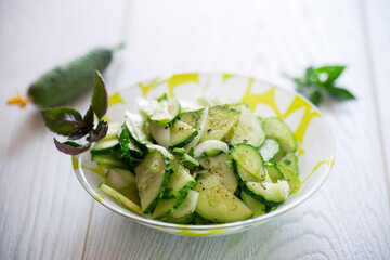 fresh organic cucumber salad with herbs and basil in a plate