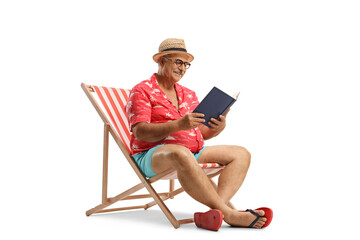 Mature tourist with a book sitting in a bech chair and reading