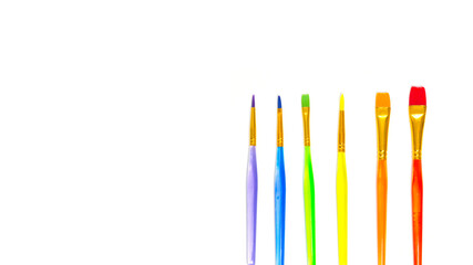 Multi-colored brushes for painting on a white background. Colors of rainbow