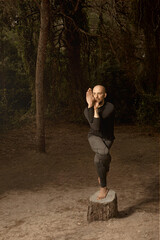 Latin male teacher performing yoga on nature
