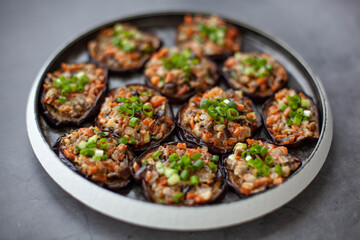 Eggplants baked with vegetables on a black plate