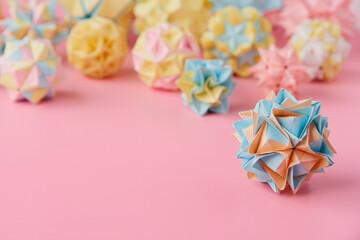 Set of multicolor handmade modular origami balls or Kusudama Isolated on pink background. Visual...