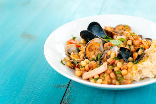 Fregula con frutti di mare, tipica pasta sarda condita con cozze, gamberi, calamari e vongole, Cucina Italiana di mare