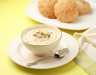 Indian dessert Shrikhand served with hot puri