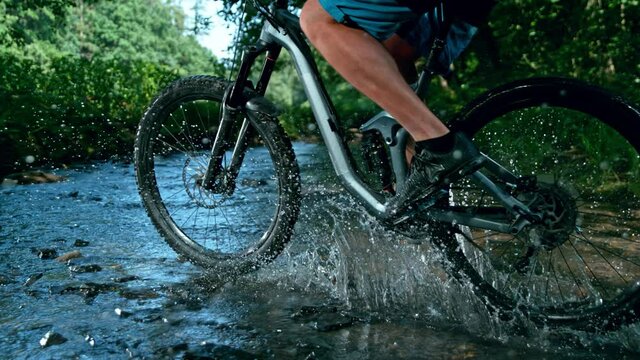 Super Slow Motion Detail Shot of Man on Mountain Bike Crossing The River at 1000 fps.