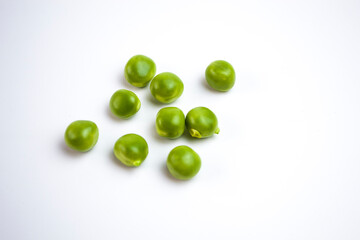 Scattered green peas on the white background closeup