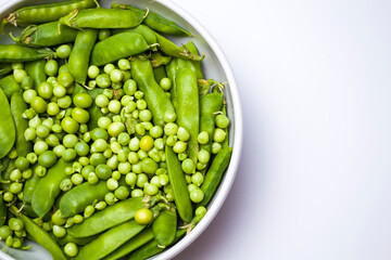 fresh green peas in a bowl isolated on a white background