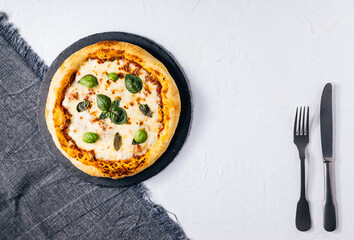 Traditional Margherita Pizza with basil, tomato, olive oil, mozzarella on a rustic background