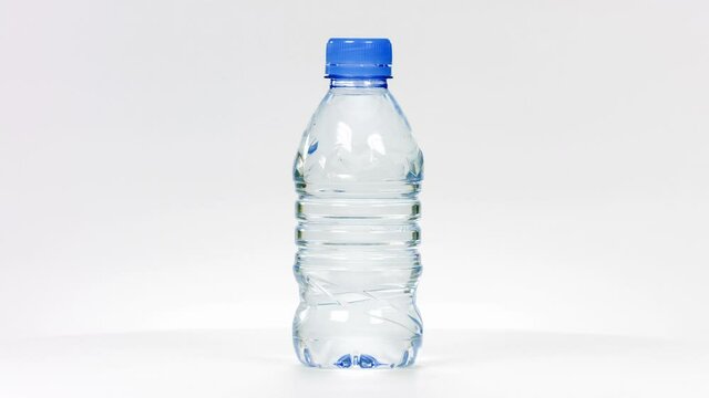 Small water plastic bottle rotates on a white background.