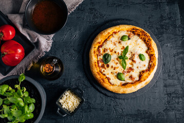 Traditional Margherita Pizza with basil, tomato, olive oil, mozzarella on a rustic background