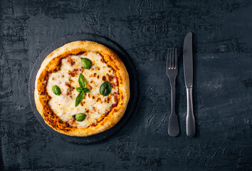 Traditional Margherita Pizza with basil, tomato, olive oil, mozzarella on a rustic background