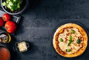 Traditional Margherita Pizza with basil, tomato, olive oil, mozzarella on a rustic background