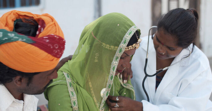 Young female South Asian doctor doing a checkup on another female