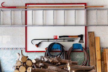 Ax, hook, hoses and ladder hang on white board