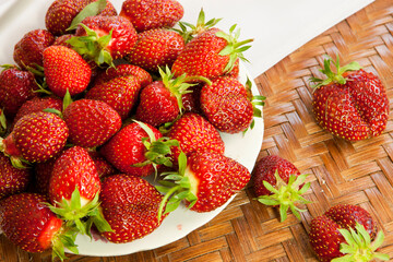 Ripe strawberries in a plate. Fresh berries, fragrant . Old wooden table in a rustic style, close-up