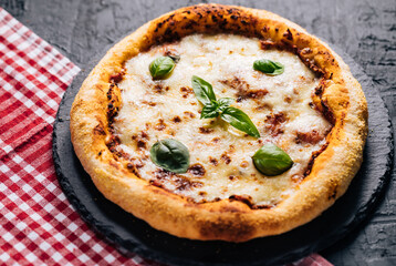 Traditional Margherita Pizza with basil, tomato, olive oil, mozzarella on a rustic background