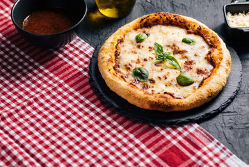 Traditional Margherita Pizza with basil, tomato, olive oil, mozzarella on a rustic background