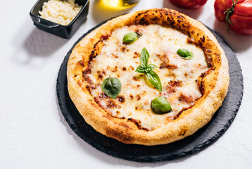 Traditional Margherita Pizza with basil, tomato, olive oil, mozzarella on a rustic background