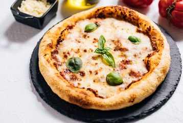 Traditional Margherita Pizza with basil, tomato, olive oil, mozzarella on a rustic background