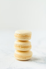 Stack of yellow macaroons with shallow depth of field on the white background.