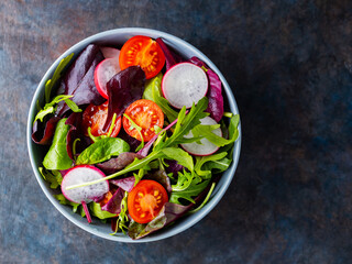 Salad with cherry tomatoes, radish and mix salad. Healthy salad, leaves mix salad. Paleo diet concept. Copy space. Top view