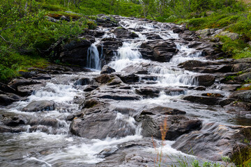 long-term photos of a river through stones and  the green nature in norway