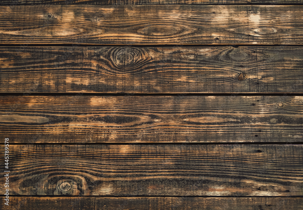 Wall mural Texture of old burnt brown wood close-up. Natural background. Copy space.