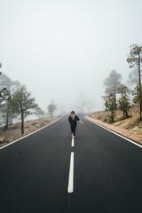 Dziewczyna biegnąca wzdłuż drogi we mgle