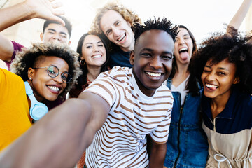 Group of multiracial happy best friends taking selfie photo with smartphone camera - Cheerful young...