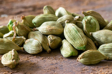 Cardamom ( Elettaria cardamomum) pods over a wooden table. Close up macro view with copy space and selective focusing.