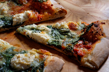 Italian pizza with spinach, mozzarella and parmesan. Thin crispy pizza base. Close-up.