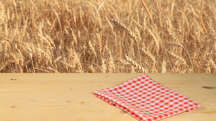 Empty wooden rustic table on the background of a wheat field, the concept of harvesting. Jewish holiday of Shavuot, mockup for design and product demonstration,