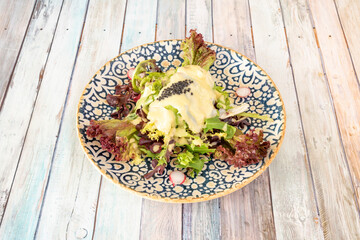 deliciosa ensalada de aguacate y bacalao cocido con huevas de caviar y crema de pil pil sobre brotes de lechuga y rabano