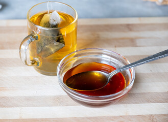 Raw honey and glass mug of tea