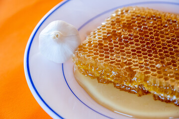 Hoeny with garlic on orange background