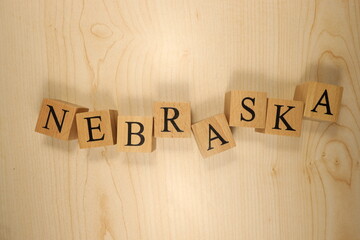 The word Nebraska was created from wooden letter cubes. Cities and words.