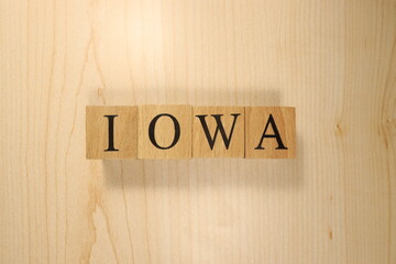 The word Iowa was created from wooden letter cubes. Cities and words.