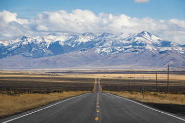A long, straight road heading into the distant mountains in Idaho.