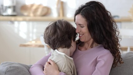 Happy family at home. Young caucasian mom embrace small son touching hair with tender caring smile. Single mother of 30s bonding with preschooler boy. Close up of cute mommy loving parent hugging kid