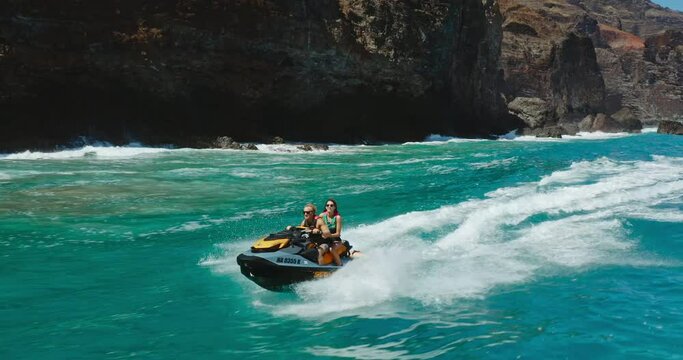 Epic jet ski ride, couple riding jet ski in front of amazing tropical island