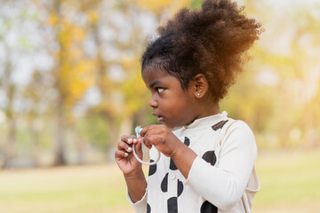 African American toddler little girl playing outdoor in the park. Cute black people child girl with hair curly outdoor