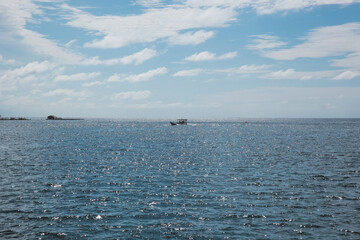 A boat sailing on the middle of sea with sparkling water