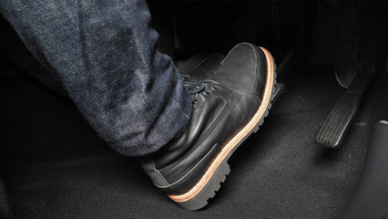 Man foot and accelerator and brake pedal inside the car or vehicle and copy space which black color...