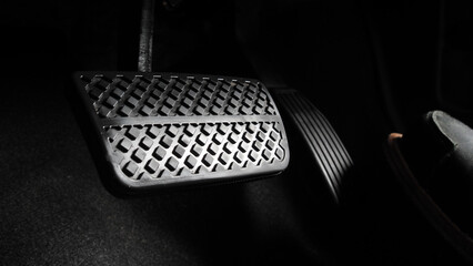 Man foot and accelerator and brake pedal inside the car or vehicle and copy space which black color...