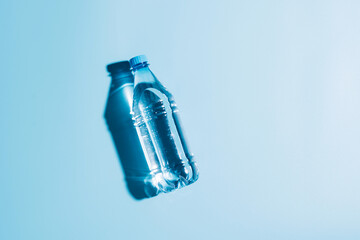 Pure drinking mineral water in a transparent plastic bottle on a blue background. 