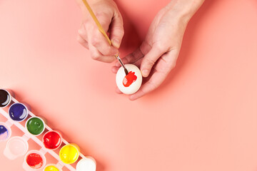 A girl paints eggs red for Easter
