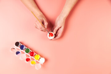 A girl paints eggs red for Easter